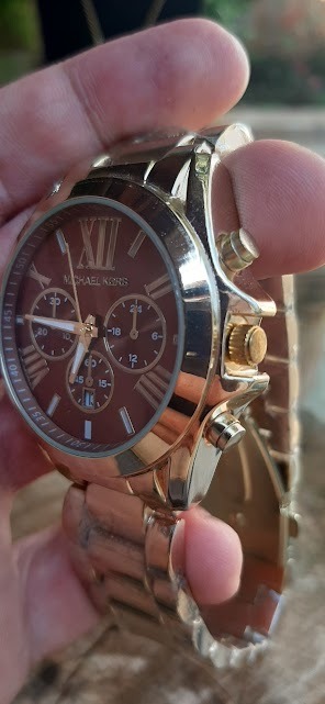 Relógio Michael Kors Dourado fundo marrom