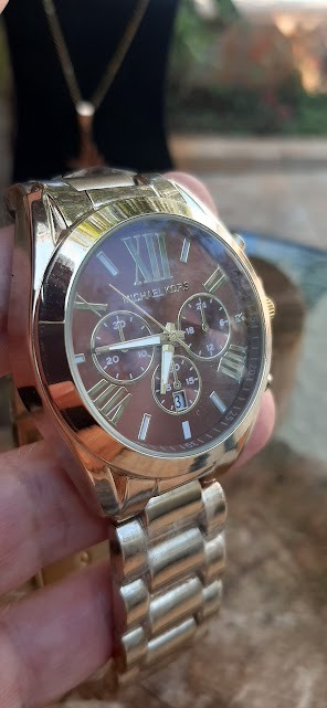 Relógio Michael Kors Dourado fundo marrom